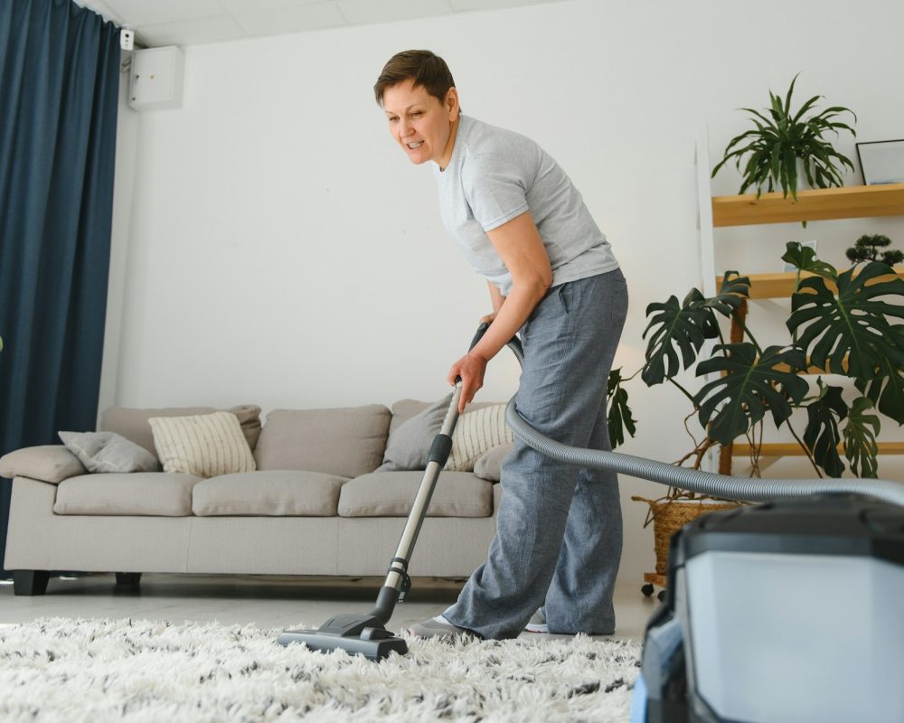 Middle-aged woman cleaning new apartment.